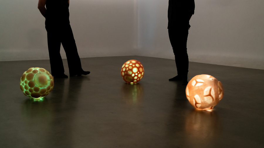 View of the installation with three spheroid robots and two humans